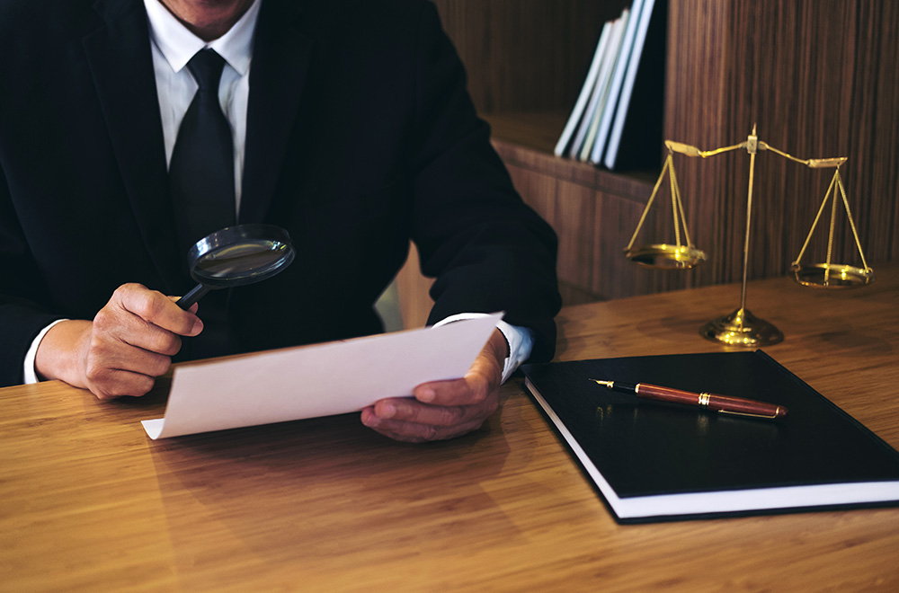 Collection lawyer looking at paper using magnifying glass
