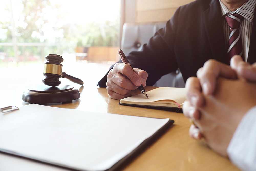 Collection lawyer writing notes while talking to client