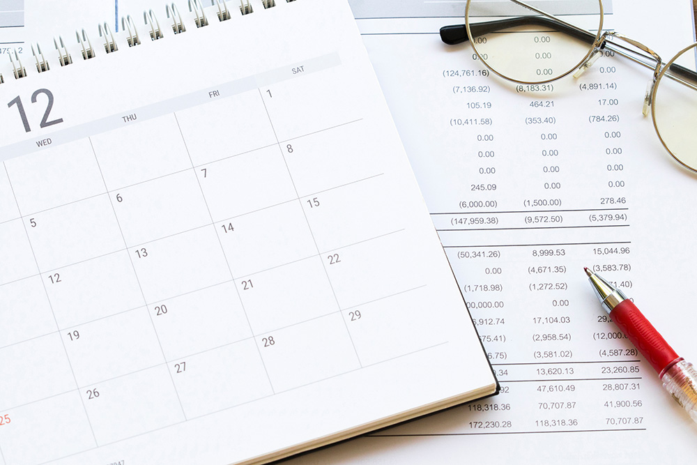 Calendar, pen, and reading glass sitting on debt report